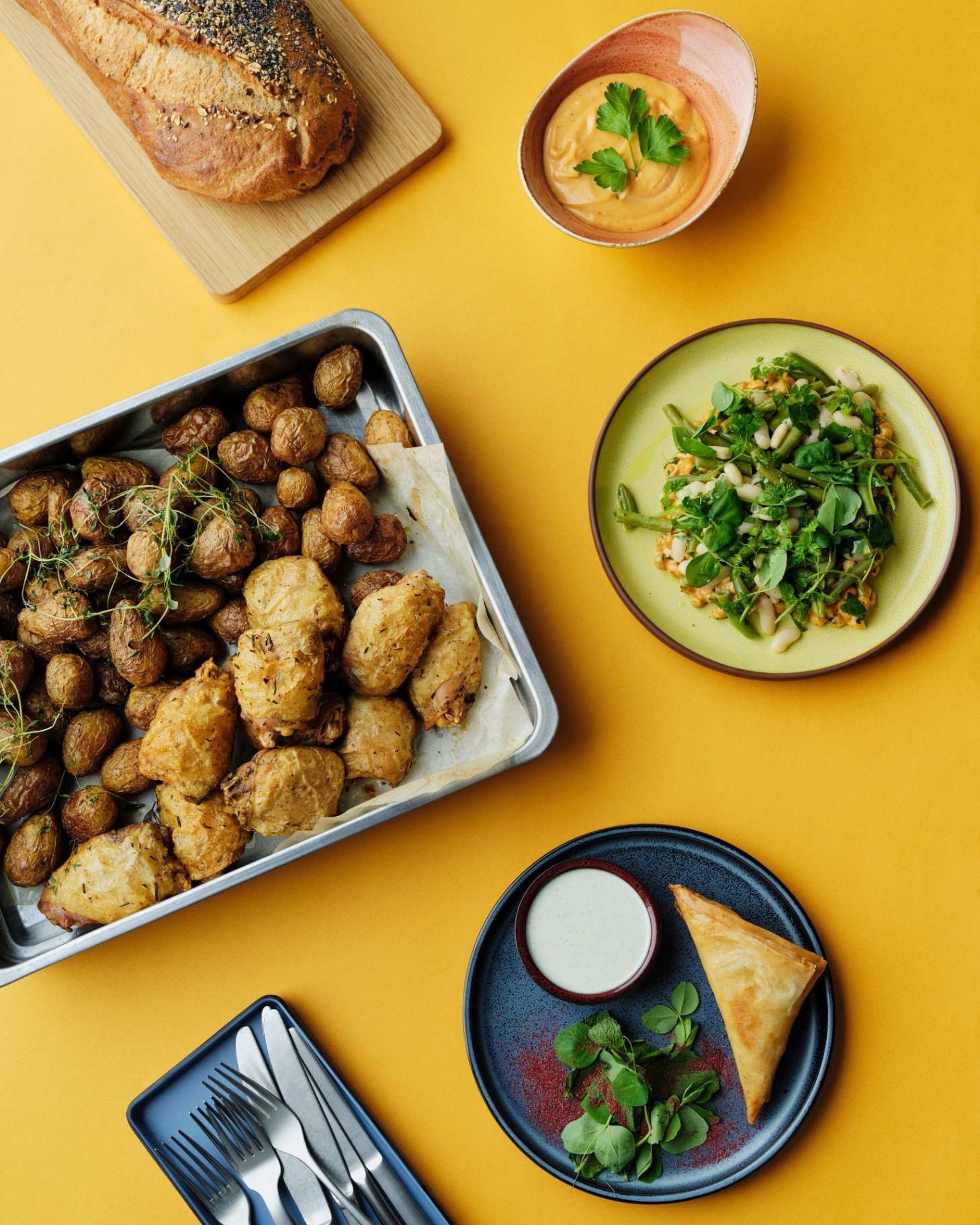 Frokostordning med friskbagt brød, kartofler, kylling og salat