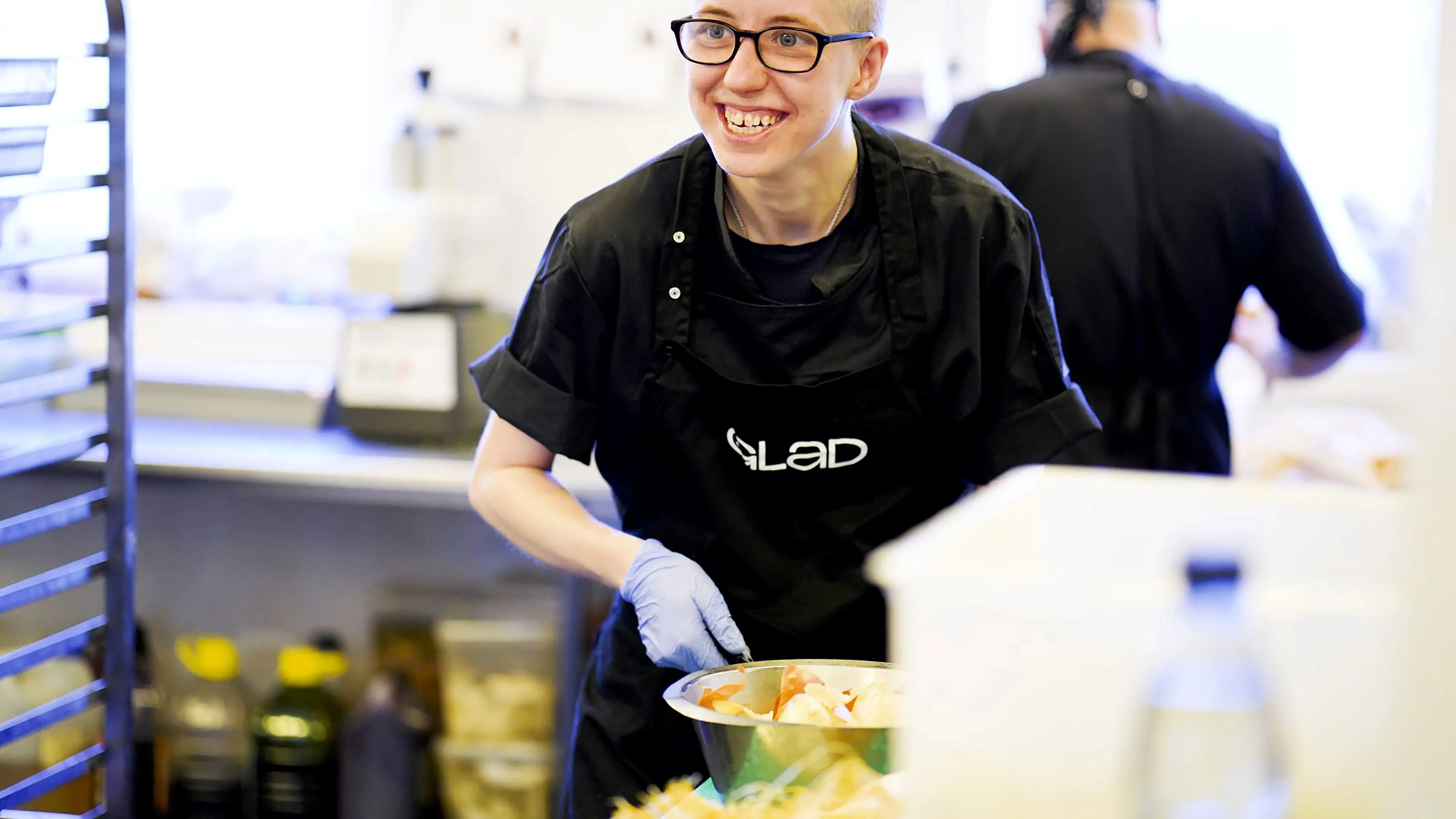 Medarbejder i Glad Mad-køkkenet gør frokosten klar
