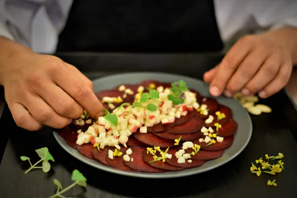 Kok fra Corporate Cooking anretter rødbedecarpaccio med æble og urter
