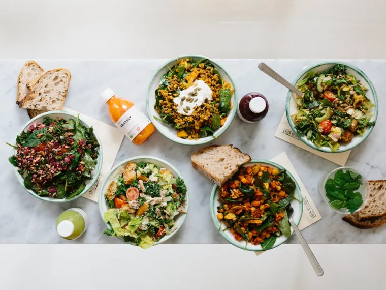 Grønt frokostbord med salater, bælgfrugter, surdejsbrød og friskpresset juice